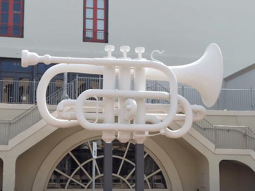 Grandure in Iron: The Giant Trumpet Sculpture Gracing Old Galveston Square, a Stunning Landmark. Learn more with an historic waking tour from Galveston Tour Company